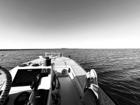 A view from the helm of a boat, showcasing the console and a relaxed moment with feet up, perfect for enjoying a day on the water.