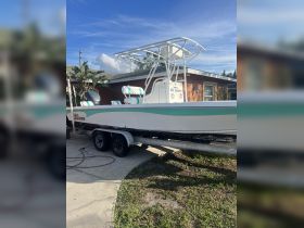 A pristine Sea Chaser boat parked on a trailer, showcasing its sleek design and vibrant colors, perfect for fishing or leisure outings.