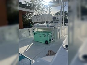 Inside view of a well-equipped boat helm featuring comfortable seating and a cooler, perfect for a day out on the water.
