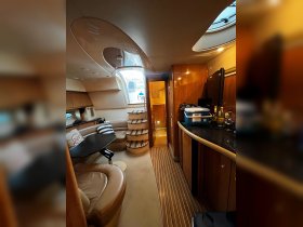 Interior view of a luxurious boat cabin featuring comfortable seating and a well-equipped helm area, perfect for relaxing and enjoying the journey on the water.