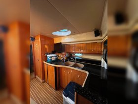 Interior view of a well-equipped boat kitchen, featuring a sleek design with wooden cabinetry and modern appliances, perfect for onboard dining and entertaining.