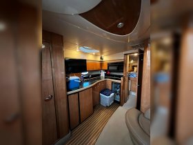 Interior view of a well-equipped boat cabin featuring a kitchen area and seating, perfect for comfortable cruising and entertaining on the water.