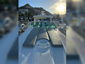 A view of the spacious helm area on a yacht, featuring comfortable seating and a sleek design, perfect for enjoying time on the water.