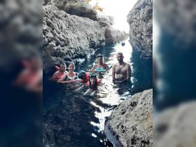 A group of snorkelers enjoys exploring a stunning cave, surrounded by rocky formations and clear waters — a perfect adventure for aquatic enthusiasts.