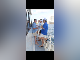 A group of friends enjoys drinks on the deck of a boat, capturing the essence of a fun day on the water.