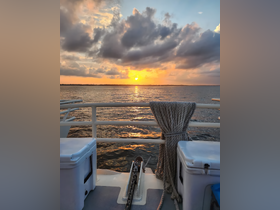 A serene sunset view from the deck of a boat, showcasing the tranquil waters and vibrant sky — perfect for evening cruises.