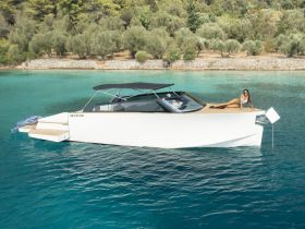 A woman relaxes on the bow of a sleek yacht, enjoying the stunning turquoise waters — an ideal scene for luxury boating experiences.