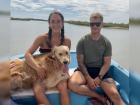 A joyful moment on the water with friends and a golden retriever, showcasing the fun of boating adventures.