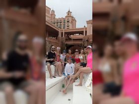A lively group of friends enjoys their time on a boat, capturing the essence of celebration and camaraderie against a stunning backdrop.
