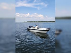 A person navigates a boat on calm waters, showcasing a perfect day for boating adventures.