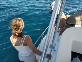 A group of children enjoys a fishing experience on a boat, showcasing the excitement of a day on the water.