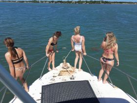 A group of friends enjoys a sunny day on the boat, poised for fun in the water. Perfect for summer adventures and memorable outings.