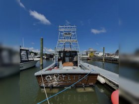 A striking view of the 'OUTLIER' boat docked at Virginia Beach, showcasing its sleek design and fishing equipment — perfect for fishing charters and water adventures.