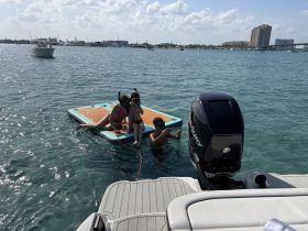 A fun day on the water as kids enjoy snorkeling and playing on a floating mat, creating unforgettable memories in the sun.
