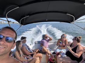 A lively group enjoys a fun day on the water, sharing drinks and laughter aboard a boat — perfect for creating unforgettable memories with friends.