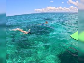 Two children enjoy swimming in the crystal-clear waters, perfect for snorkeling adventures and family fun in the sun.