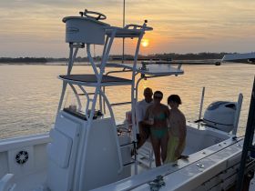 A family poses together on their boat at sunset, capturing a memorable moment on the water — perfect for family outings and sunset cruises.