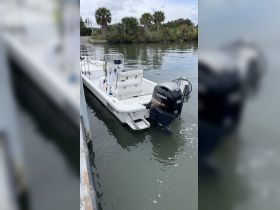 A sleek center console boat equipped with a Yamaha motor, docked in calm waters surrounded by lush greenery — perfect for fishing or leisurely outings.