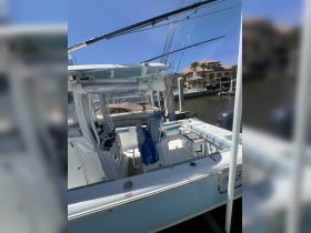 Interior view of a well-equipped boat helm featuring seating and fishing gear, perfect for a day out on the water.