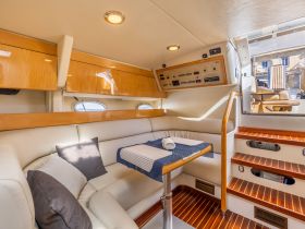 Interior view of a luxurious boat cabin featuring comfortable seating and modern amenities, perfect for relaxing during a day on the water.