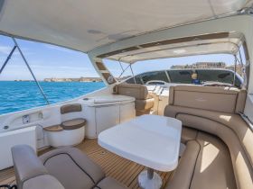 A spacious and elegantly designed interior of a boat featuring comfortable seating and a well-equipped helm, perfect for relaxing while cruising on the water.