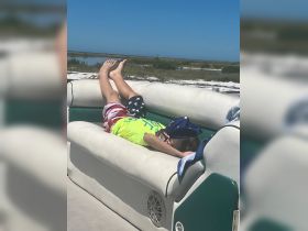 A child relaxes on the boat's seating under the sun, enjoying a perfect day on the water. Ideal for family outings and summer adventures.