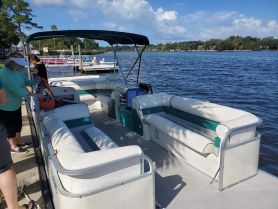 The interior of a pontoon boat featuring spacious seating, perfect for relaxing on the water. Guests are preparing for a day of fun on the river.