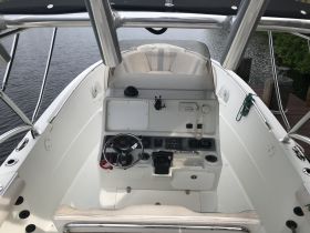 A detailed view of the helm and console area inside a boat, showcasing the controls and seating, ideal for navigating the waters.