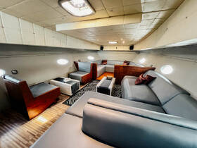 Interior view of a spacious boat lounge area featuring comfortable seating and modern decor, perfect for relaxing during a day on the water.