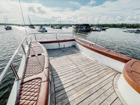 Interior view of a spacious boat seating area, showcasing comfortable leather upholstery and a wooden deck, perfect for relaxing on the water.