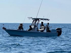 A group of anglers enjoy a day of fishing on the open ocean, showcasing the thrill of sport fishing from their boat.