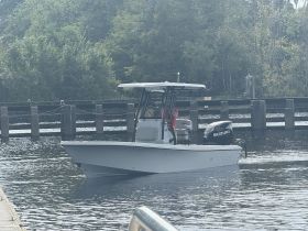 A sleek Blazer Bay speedboat is seen navigating through calm waters, showcasing its modern design and powerful Suzuki engine.