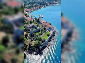 A stunning aerial view of a picturesque coastline featuring charming architecture and a serene harbor, perfect for showcasing the beauty of coastal destinations.