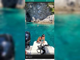 A joyful child climbs aboard a boat, enjoying a sunny day in the crystal-clear ocean — a perfect moment of family fun on the water.