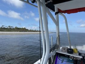 A view from the helm of a boat, showcasing the console and surrounding water, perfect for navigating coastal waters.
