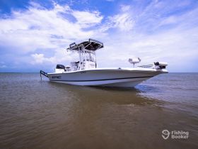 A striking view of an Epic speedboat cruising through calm waters, showcasing its sleek design against a backdrop of blue skies and fluffy clouds.