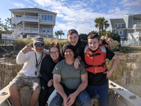 A cheerful group of family members poses on a boat, showcasing their excitement for a day on the water. Perfect for family outings and adventures.