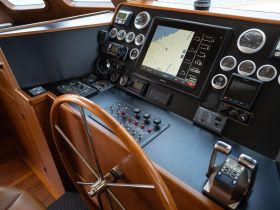 A detailed view of the helm and control console inside a boat, showcasing navigation equipment and steering wheel — ideal for understanding boat operations.
