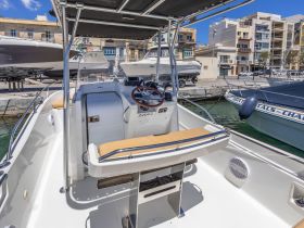 Interior view of a boat's helm and seating area, showcasing the modern console and comfortable layout, perfect for a day on the water.