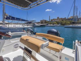 A well-appointed helm area of a boat, featuring comfortable seating and a clear view of the marina, perfect for navigating the waters.