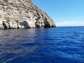 A stunning view of a rocky coastline against the deep blue ocean, perfect for showcasing the natural beauty of marine destinations.