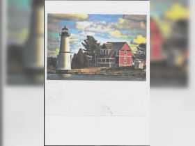 A scenic view featuring a lighthouse and a red house by the water, capturing a tranquil moment in nature.