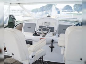 A clean and modern helm area of a boat featuring advanced navigation equipment and comfortable seating, ideal for smooth sailing adventures.