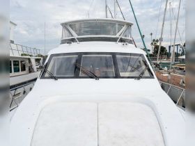 A clear view of the front exterior of a yacht docked at the marina, showcasing its sleek design and structure.