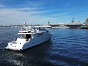 A stunning yacht named 'Lady' cruising in the harbor, showcasing its elegant design against a backdrop of the San Diego skyline.