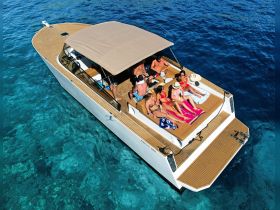 A lively group enjoys a sunny day on a boat, lounging and soaking up the sun — perfect for summer parties and fun on the water.