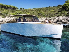 A woman relaxes on the deck of a sleek boat, enjoying the stunning clear waters and beautiful surroundings — perfect for a day of leisure on the water.