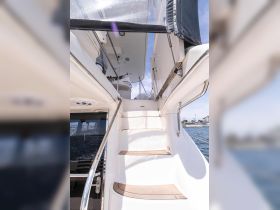 A view of the interior stairs leading to the helm of a yacht, showcasing the elegant design and spacious layout — perfect for navigating the open waters.