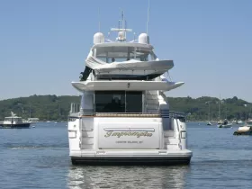 A stunning view of a yacht named 'Impromptu' cruising in calm waters near Centre Island, NY, showcasing its elegant design and serene surroundings.