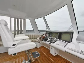 The interior helm of a modern boat showcases a sleek design with a comfortable captain's chair and advanced navigation equipment, perfect for a smooth sailing experience.